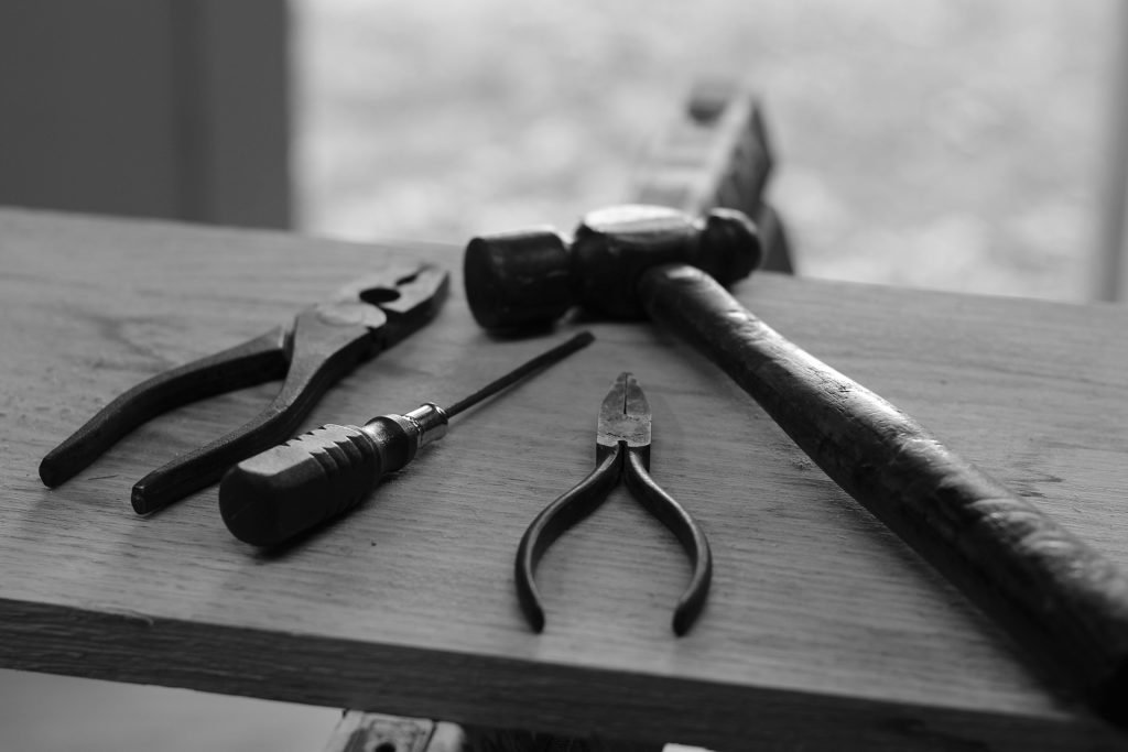 Black and white photo of hand tools on a piece of wood